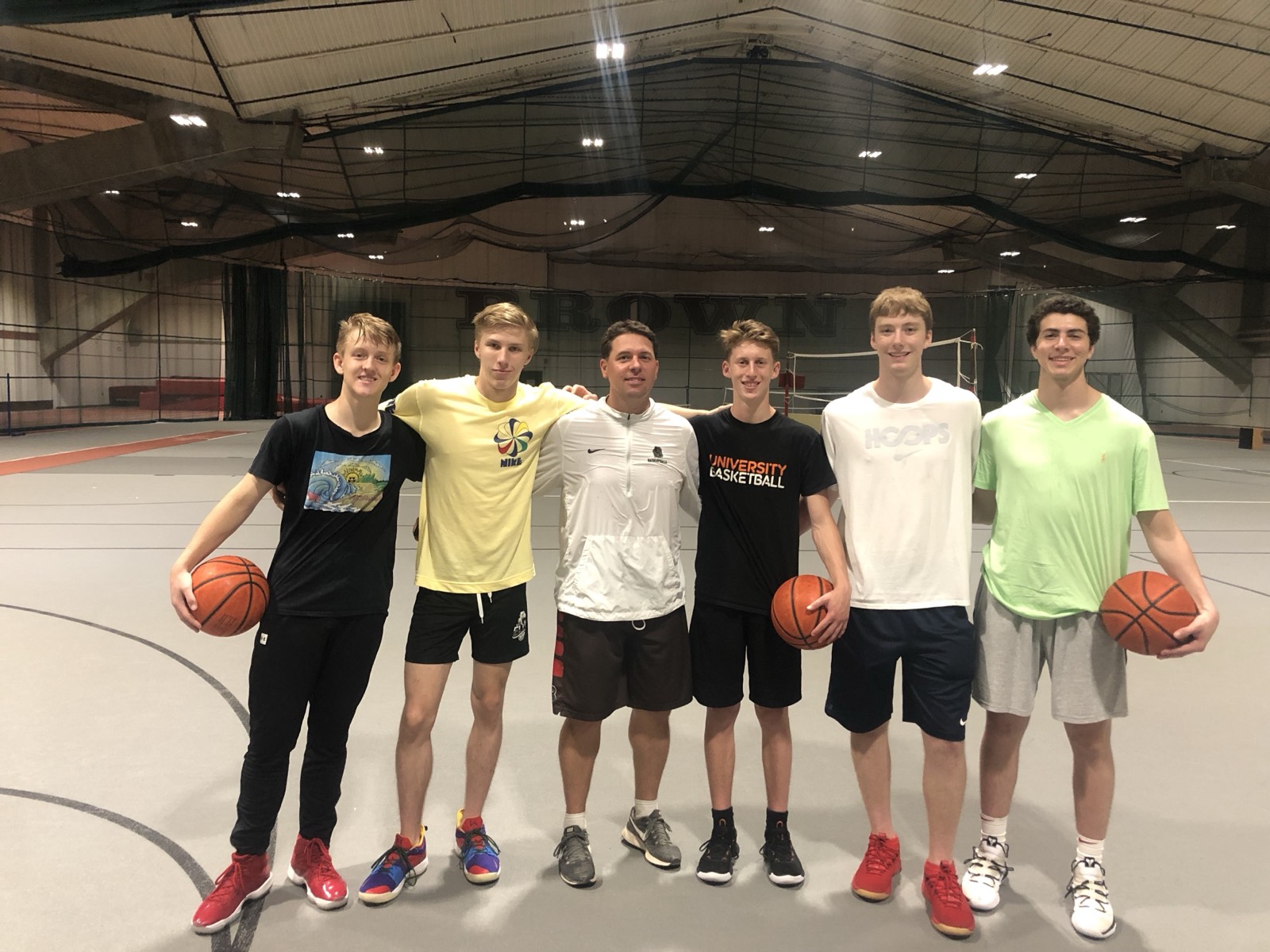 Tour athletes with a coach inside the Brown University practice facility.
