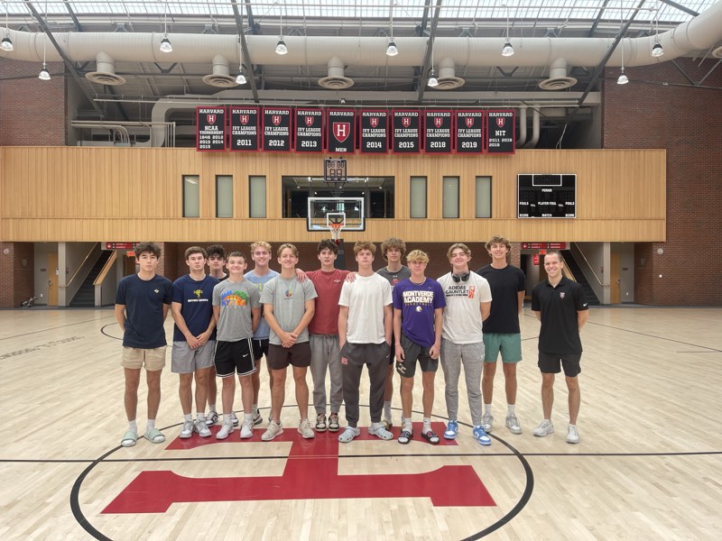 The tour group at centre court at Harvard, under the Ivy League championship banners.