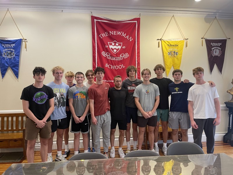 The tour group beneath the Newman School banner in Boston.