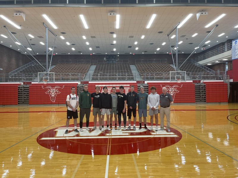 The tour group at centre court in the WPI arena with a coach.
